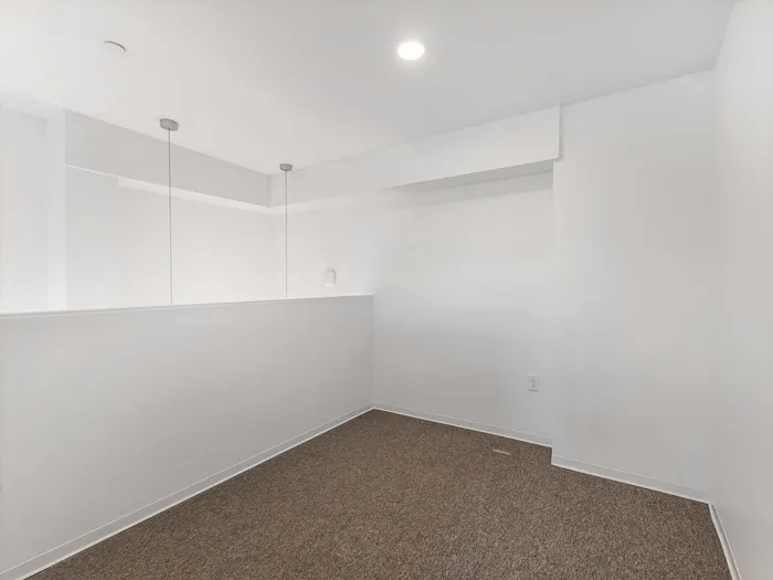Carpeted loft mezzanine with bright recessed lighting at Koz on 4th.