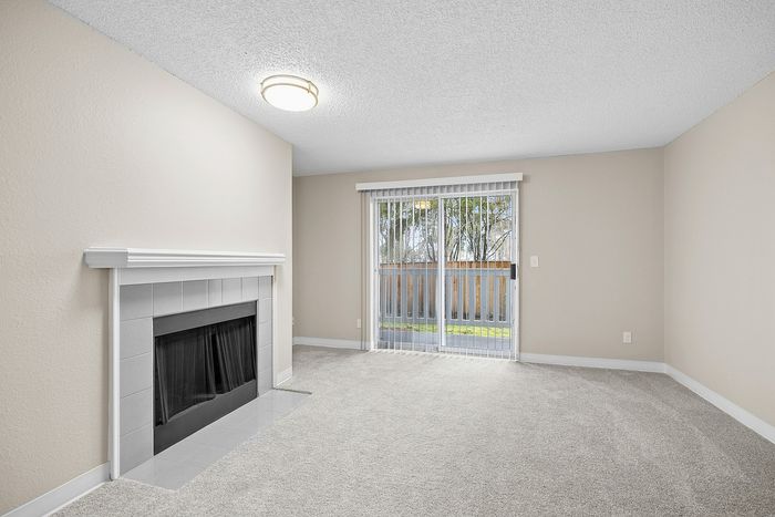 living room of C1 renovated floorplan at Timber Flats with window and fireplace