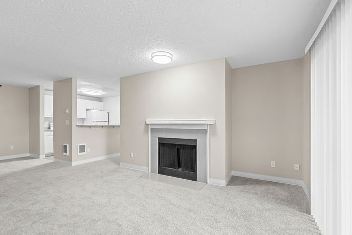 angle 2 of living room of C1 renovated floorplan at Timber Flats with fireplace and view into kitchen