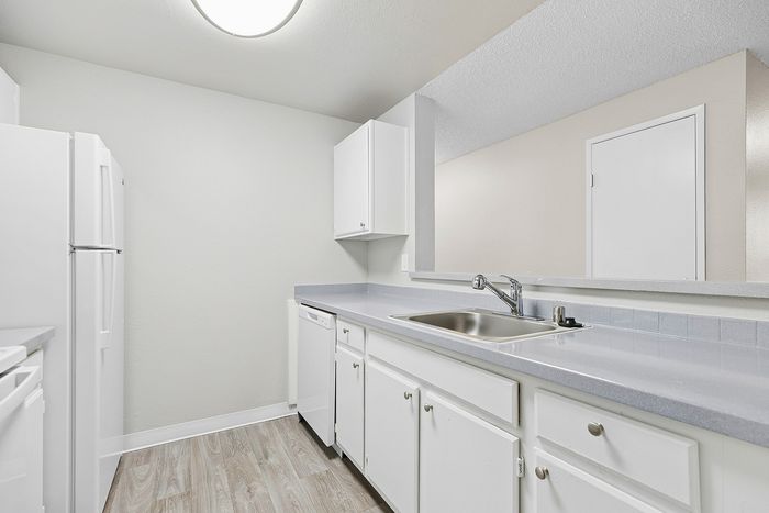 angle 2 of kitchen in C1 renovated floorplan at Timber Flats white cabinets white appliances and grey countertops