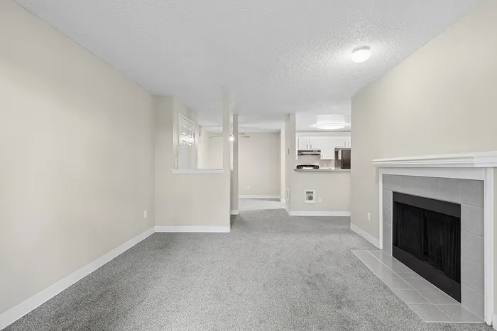 angle 3 of living room at B1 renovated floorplan at Timber Flats showing fireplace and view into dining room