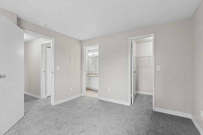 angle 2 of primary bedroom in B1 renovated floorplan at Timber Flats with walk-in closet and bathroom
