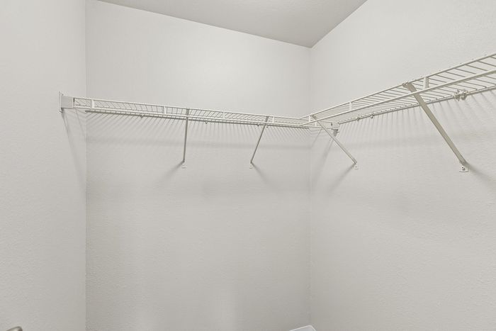 walk-in closet in the primary bedroom in B1 renovated floorplan at Timber Flats with wire shelving