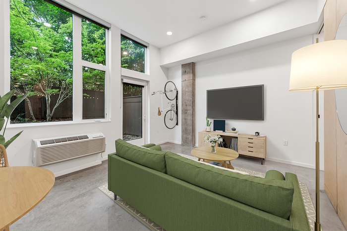 living room with green couch tv and tv with console at Artisan