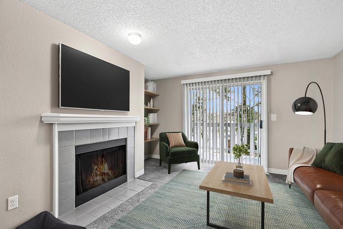Virtually stages living room at Timber Flats with a couch, table, chair, tv