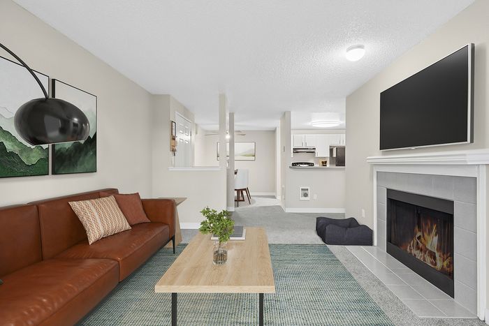 Virtually staged living room at Timber Flats with a couch, table, chair, tv