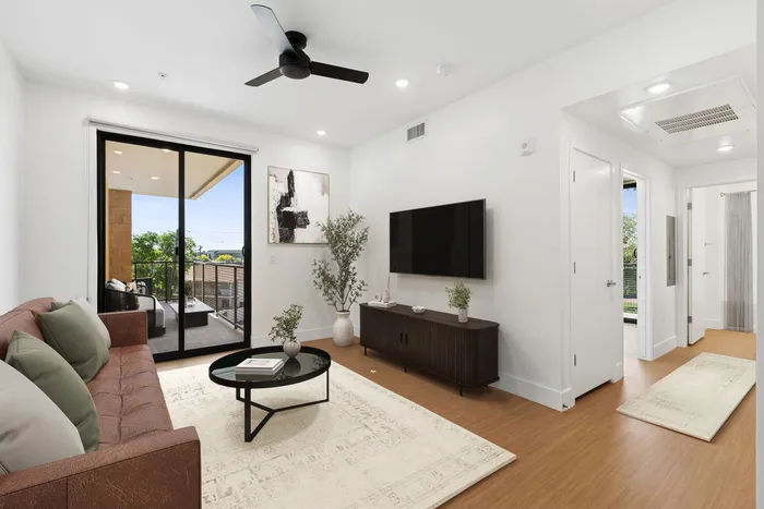 Midtown Phoenix, AZ, Apartments Near Grand Canyon University - Asa Midtown - Bright Apartment Living Room With Private Balcony, Ceiling Fan, Wood Style Flooring, And Modern White Walls.