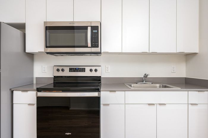 Closeup of kitchen at Lyra apartments with grey countertops and stainless steel appliances