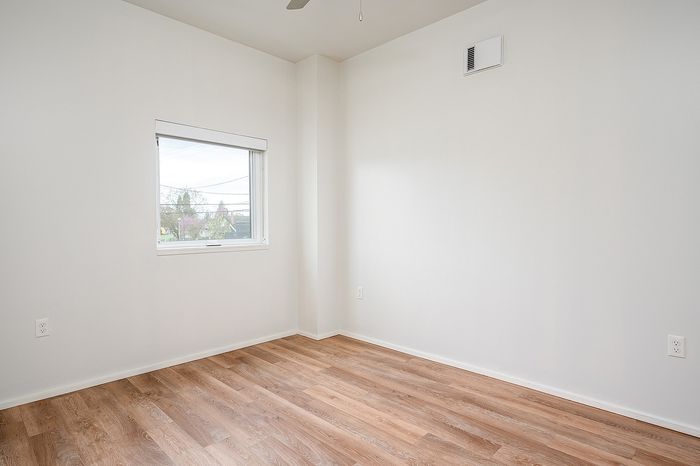 One Bedroom at Lyra Apartments - bedroom with window and hardwood floors