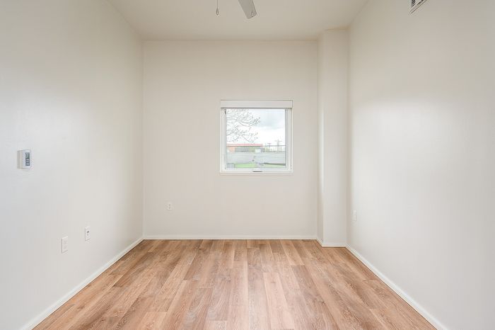 One Bedroom at Lyra Apartments - bedroom with window and hardwood floors