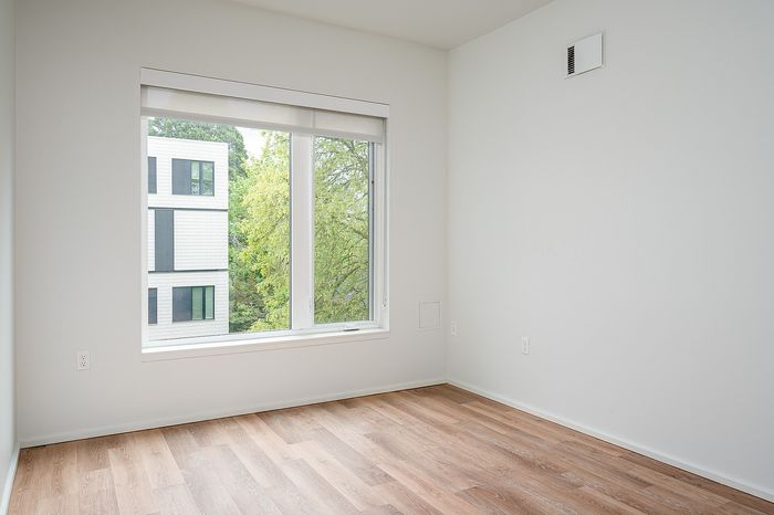 One-Bedroom at Lyra Apartments - living room with window and hardwood floors