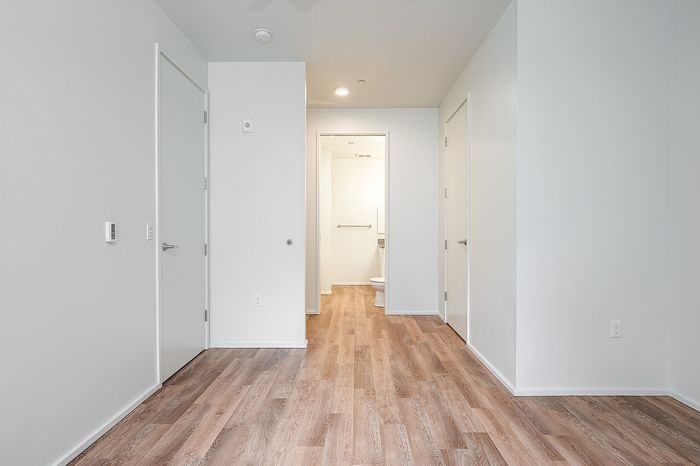 One-Bedroom at Lyra Apartments - bedroom with view into the closet and bathroom