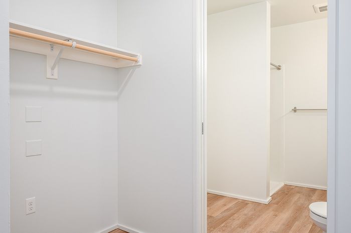 One-Bedroom at Lyra Apartments - view into the closet and bathroom with a shelf and space to hang clothes