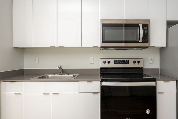 One-Bedroom at Lyra Apartments - closeup of kitchen with grey countertops and stainless steel appliances