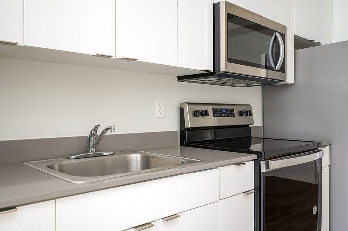 One-Bedroom at Lyra Apartments - closeup of kitchen with grey countertops and stainless steel appliances