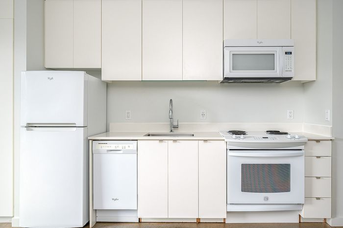 Cassi Apartments - kitchen with white appliances and white countertops and cabinets