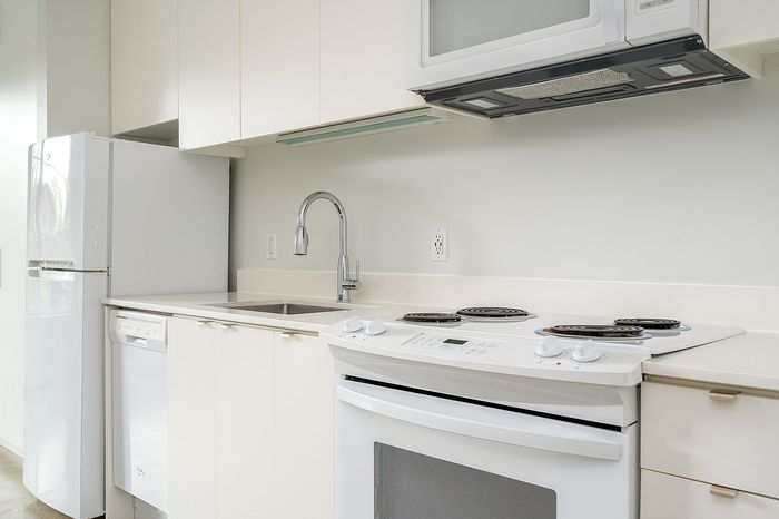 Cassi Apartments - kitchen with white appliances and white countertops and cabinets