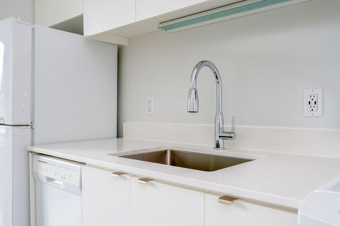 Cassi Apartments - kitchen with white appliances and white countertops and cabinets