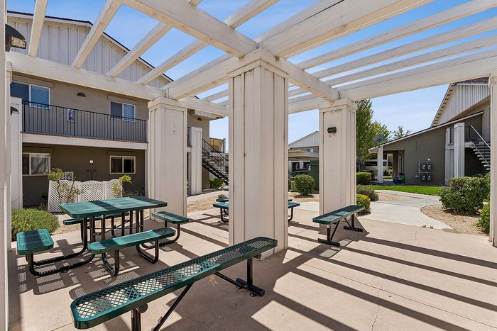 Community area with seating, partial shade, and sunlight.