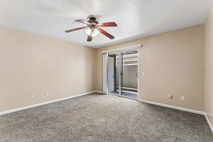 Living Area with carpet, ceiling fan, and patio.