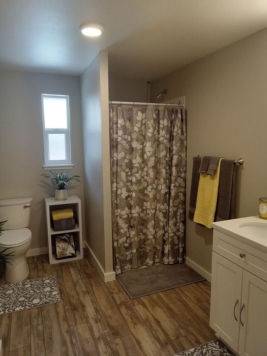 Neat bathroom with a large mirror and neutral tones at Lakeside Place.