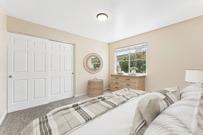 virtually staged bedroom with closet, carpet, and window.