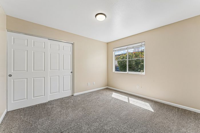 bedroom with carpet, window, closet.