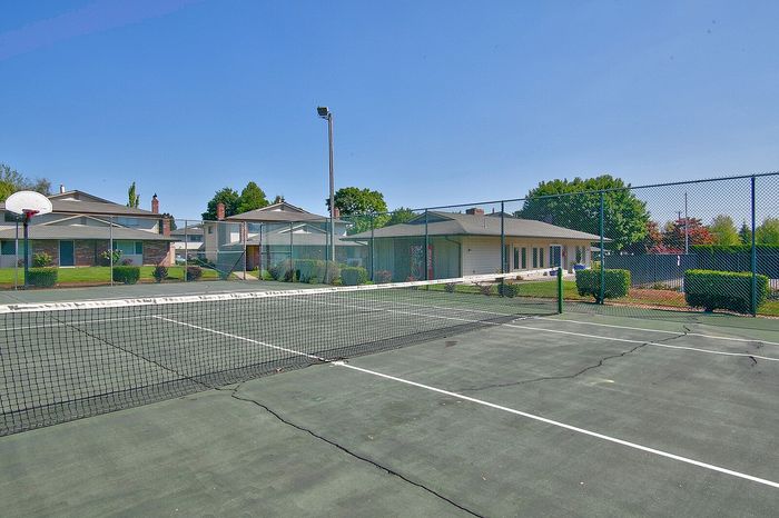 Fenced community tennis and sports court area on a sunny day at CAMPBELL PARK.