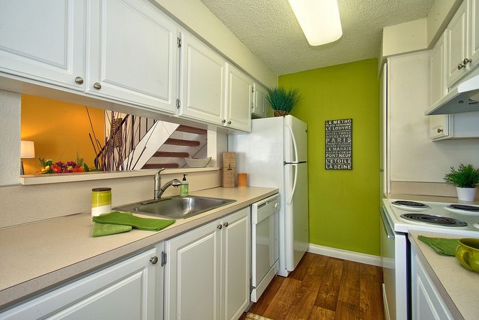 Efficient kitchen setup with ample white overhead cabinets for storage at CAMPBELL PARK.