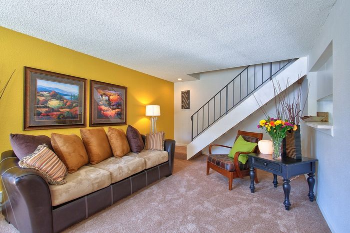 Stylishly decorated living room featuring a warm brick accent wall at CAMPBELL PARK.