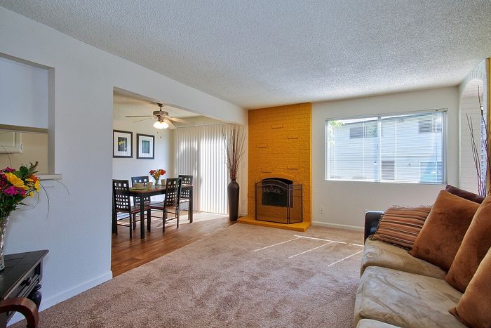 Bright living space layout looking past a dining set toward a window at CAMPBELL PARK.