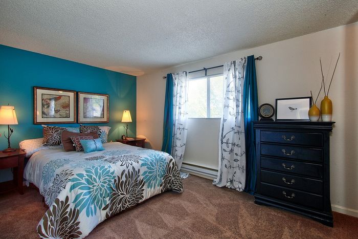 Beautifully decorated bedroom showcasing teal and neutral accent colors at CAMPBELL PARK.