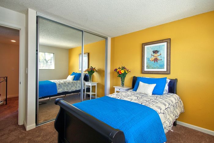 Cozy bedroom space featuring a mirrored sliding closet door at CAMPBELL PARK.