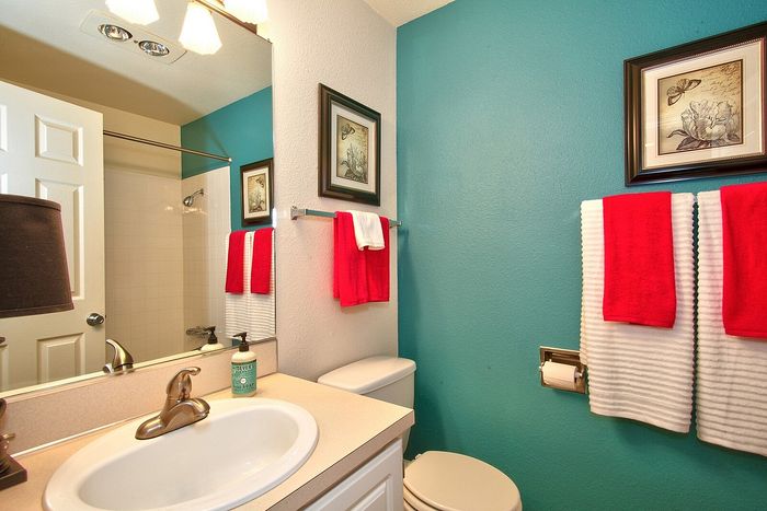 Updated bathroom vanity with a vibrant teal painted accent wall at CAMPBELL PARK.