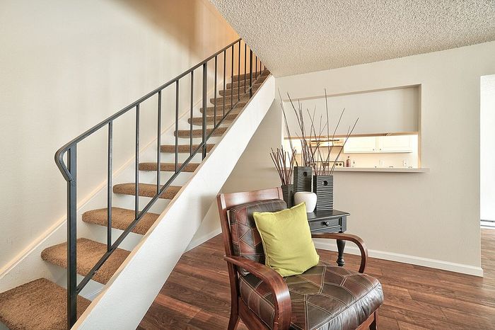View from a furnished living space looking up a wooden staircase at CAMPBELL PARK.