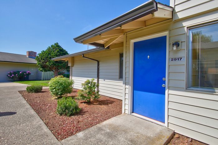 Blue front door accenting a modern apartment building exterior at CAMPBELL PARK.