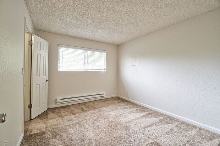 Vacant bedroom with light-colored walls and carpet flooring at CAMPBELL PARK.
