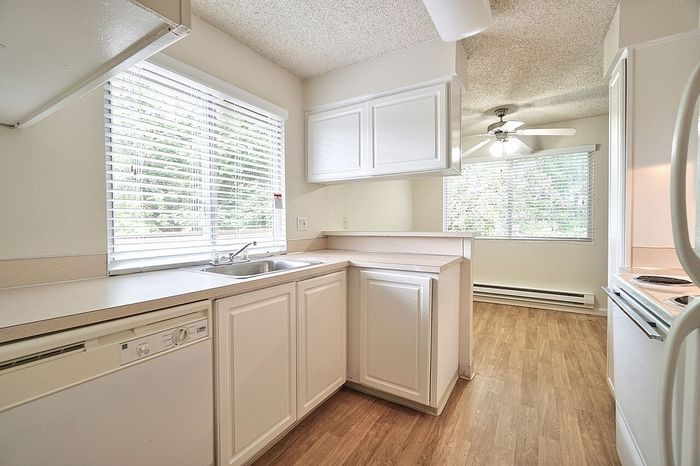 Classic kitchen layout with white cabinetry and solid countertops at CAMPBELL PARK.