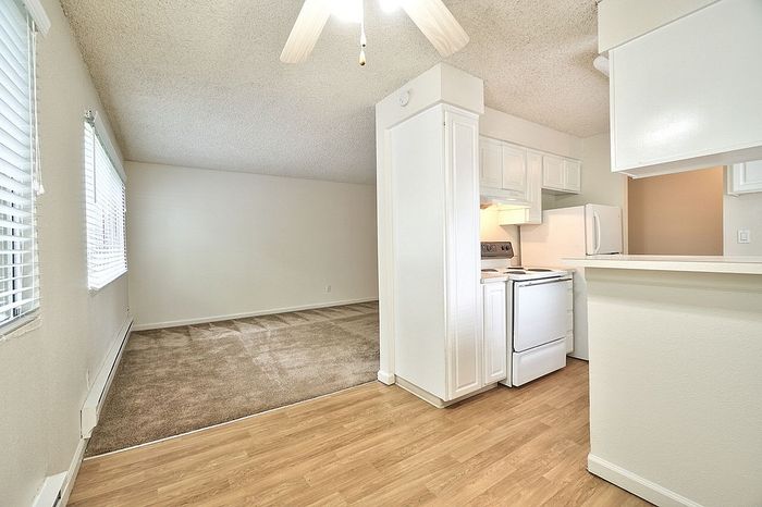 Unfurnished living area with wood-style flooring looking toward a kitchen at CAMPBELL PARK