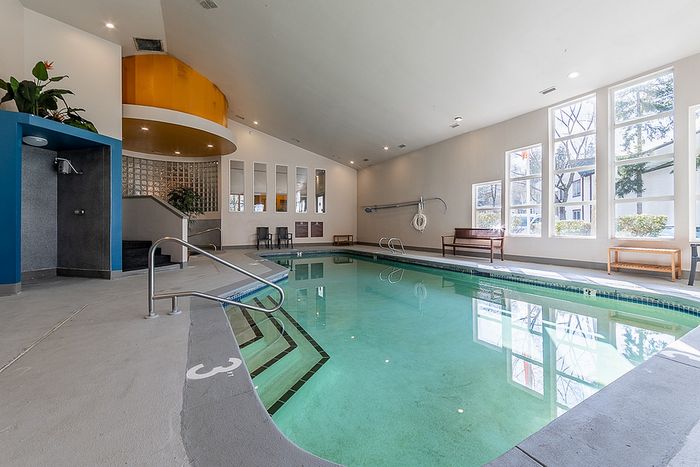 Large indoor pool space surrounded by relaxing deck lounge chairs at Berkeley Heights Apartment Homes.