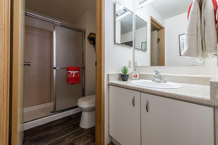Tidy bathroom layout featuring a bright vanity mirror at Berkeley Heights Apartment Homes.