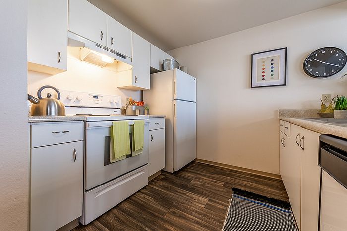 Well-lit galley kitchen with complete appliances at Berkeley Heights Apartment Homes.