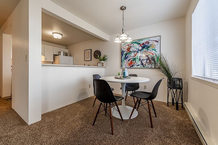 Intimate dining table set up right next to an open kitchen bar at Berkeley Heights Apartment Homes.