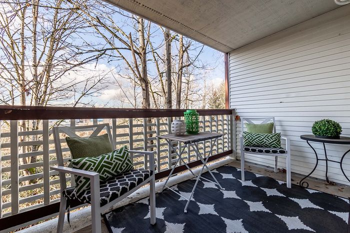 Private covered apartment balcony with outdoor furniture at Berkeley Heights Apartment Homes.