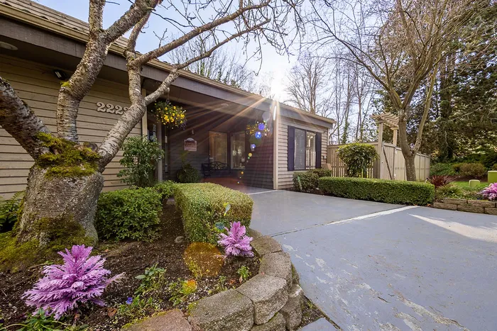 Landscaped entry path with flowers leading to the leasing office at Creekwood Apartments.