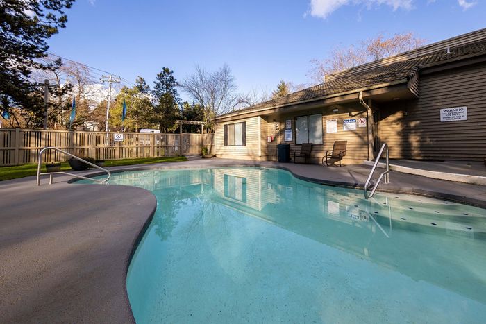 Sparkling outdoor swimming pool under a bright sky at Creekwood Apartments.