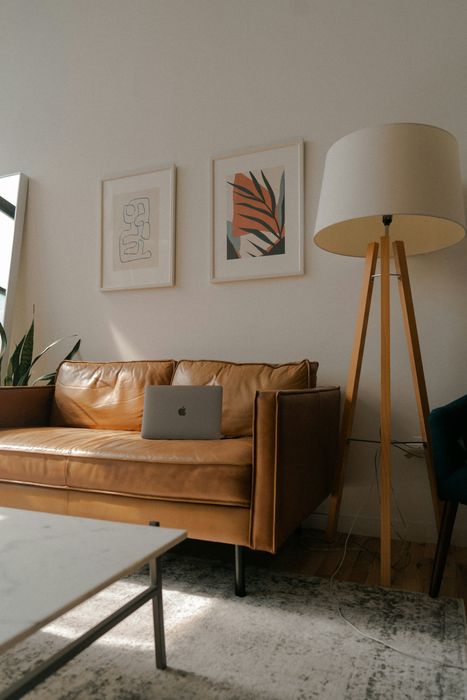 brown sofa and large tripod lamp