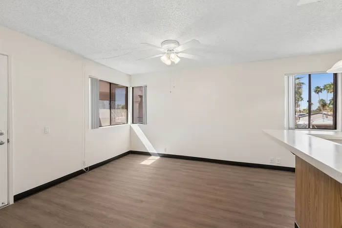 Living Room in a unit at Orchard Mesa with wood floors and white walls
