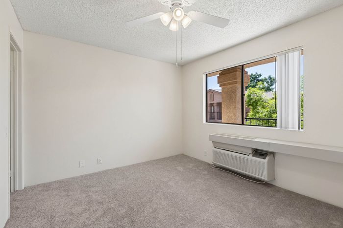 Living Room in a unit at Orchard Mesa with wood floors and white walls