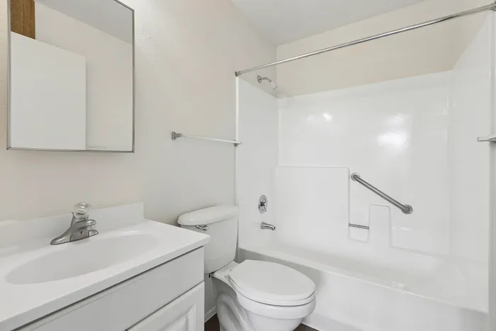 Bathroom at Orchard Mesa with white sink and cabinets and a shower/tub combo
